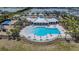 A pool with lounge chairs and umbrellas sits near a pond at 754 8Th Nw St, Ruskin, FL 33570