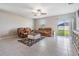 A cozy living room features plush seating, ceiling fan, and sliding glass doors to the backyard at 754 8Th Nw St, Ruskin, FL 33570