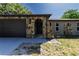 Close-up of a home's stone entrance, a dark front door, and an attached garage at 7919 Rusty Oak Dr, New Port Richey, FL 34653