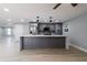 Open concept kitchen with gray cabinetry, stainless steel refrigerator and marble countertops at 7919 Rusty Oak Dr, New Port Richey, FL 34653