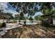 Beautiful backyard oasis with a swimming pool, complemented by trees and a seating area at 8054 38Th N Ave, St Petersburg, FL 33710