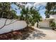 The exterior of a home with a well-maintained yard, white fence, and a view of the driveway and attached garage at 8054 38Th N Ave, St Petersburg, FL 33710