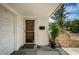 Charming front entryway featuring a storm door, a welcome mat, and a large green leafy plant at 8054 38Th N Ave, St Petersburg, FL 33710