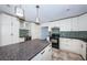 Spacious kitchen featuring an island, white cabinetry, granite counters and mosaic backsplash at 8054 38Th N Ave, St Petersburg, FL 33710