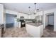Modern kitchen features white cabinetry, stainless steel appliances, granite countertops, and adjacent living area at 8054 38Th N Ave, St Petersburg, FL 33710