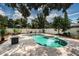 Beautiful kidney-shaped pool with stone surround, complemented by lush landscaping and a white fence at 8054 38Th N Ave, St Petersburg, FL 33710