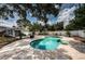 Private backyard featuring a kidney-shaped pool with stone surround, complemented by lush landscaping at 8054 38Th N Ave, St Petersburg, FL 33710