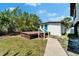View of the home's backyard with a wooden deck and a concrete walkway leading to the building at 9118 Brunswick Ln, Tampa, FL 33615
