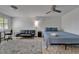 The bedroom has a blue bed, black furniture, a ceiling fan, and decorative tiled flooring at 9118 Brunswick Ln, Tampa, FL 33615