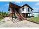 Exterior view of the stilted house showcasing stairs leading to a covered porch at 9118 Brunswick Ln, Tampa, FL 33615