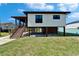 Stunning elevated home featuring modern design, and a convenient staircases with a spacious ground level with ample room at 9118 Brunswick Ln, Tampa, FL 33615