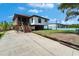 Coastal home featuring a raised foundation, screened porch, and a spacious driveway at 9118 Brunswick Ln, Tampa, FL 33615