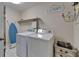 Functional laundry room featuring a washer, dryer, shelving, and ironing board at 9118 Brunswick Ln, Tampa, FL 33615