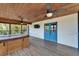 Relaxing covered porch featuring a hot tub, wood ceiling, and outdoor fans at 9118 Brunswick Ln, Tampa, FL 33615