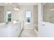 Stylish bathroom with double vanity, framed mirror, white cabinetry, and a tiled shower at 9951 Trellis Vine Way, Parrish, FL 34219
