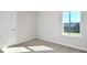 A clean, bright bedroom showcasing a door and window with neutral carpeting at 9951 Trellis Vine Way, Parrish, FL 34219