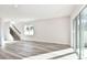 Spacious and bright living room featuring gray wood floors, a staircase, and sliding glass doors at 9951 Trellis Vine Way, Parrish, FL 34219