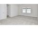 Spacious bedroom with neutral carpeting and two windows at 9955 Trellis Vine Way, Parrish, FL 34219