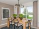 Dining room with wood table, modern light fixture, and large windows overlooking a scenic view at 9959 Trellis Vine Way, Parrish, FL 34219