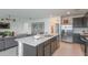 Open-concept kitchen featuring a large island with seating, stainless steel appliances, and modern finishes at 9959 Trellis Vine Way, Parrish, FL 34219