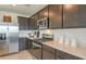 Modern kitchen with stainless steel appliances, dark cabinetry, and light countertops at 9959 Trellis Vine Way, Parrish, FL 34219