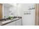 Bathroom featuring a double vanity with white cabinets, gray counters, and sailboat-themed art at 1004 Spotted Egret Loop, Ruskin, FL 33570