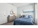 Charming bedroom featuring a cozy bed, a wooden dresser, and soothing light blue accents at 1004 Spotted Egret Loop, Ruskin, FL 33570