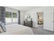 Bedroom with a gray dresser, large window and view into a living space through an open door at 1004 Spotted Egret Loop, Ruskin, FL 33570