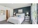Cozy bedroom featuring a modern bed, stylish accents, and natural light from a large window at 1004 Spotted Egret Loop, Ruskin, FL 33570