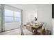 Bright dining area with a rustic wooden table, striped chairs and a large window with sheer curtains at 1004 Spotted Egret Loop, Ruskin, FL 33570