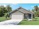 Inviting single-story home featuring a well-manicured lawn and an attached two-car garage at 1004 Spotted Egret Loop, Ruskin, FL 33570