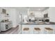 Well-lit kitchen features stainless steel appliances, light cabinetry, and a breakfast bar with seating at 1004 Spotted Egret Loop, Ruskin, FL 33570