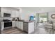 Contemporary kitchen with stainless steel appliances and an adjacent living area for seamless entertaining at 1004 Spotted Egret Loop, Ruskin, FL 33570