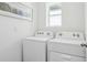 Bright laundry room featuring a washer and dryer, with a window offering natural light at 1004 Spotted Egret Loop, Ruskin, FL 33570