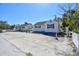 Delightful beach cottage with white siding and vibrant blue shutters, offering a welcoming curb appeal at 101 146Th Ave, Madeira Beach, FL 33708