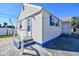 Beach cottage exterior with white siding, blue trim, steps, and a white railing leading to the front door at 101 146Th Ave, Madeira Beach, FL 33708