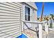 Close-up exterior of a beach home showing white siding, white railing, and brick steps to the entrance at 101 146Th Ave, Madeira Beach, FL 33708