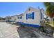 Charming beach cottage featuring white siding, blue trim, and a well-maintained concrete parking area at 101 146Th Ave, Madeira Beach, FL 33708