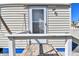 Close-up exterior of a beach house showing white siding, and a white railing, leading to the front door at 101 146Th Ave, Madeira Beach, FL 33708