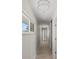 Long hallway with clean neutral paint, modern light fixtures, and light wood-look floors at 11050 7Th E St, Treasure Island, FL 33706