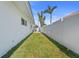 Spacious side yard featuring lush green grass and a white fence at 11050 7Th E St, Treasure Island, FL 33706