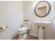 A simple bathroom featuring a pedestal sink, toilet, and decorative accents in a compact design at 1307 Forestedge Blvd, Oldsmar, FL 34677