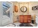 Well-appointed bathroom with wood vanity, elegant mirror, and access to the pool area at 1307 Forestedge Blvd, Oldsmar, FL 34677
