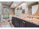 A luxurious bathroom with a beautiful granite countertop and double sinks, plus decorative mirrors and a window at 1307 Forestedge Blvd, Oldsmar, FL 34677