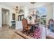 A dining room with an elegant chandelier and furniture is next to a decorative archway and the front door at 1307 Forestedge Blvd, Oldsmar, FL 34677