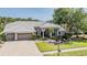 Attractive exterior of this single-Gathering house with a gray tile roof and brick driveway at 1307 Forestedge Blvd, Oldsmar, FL 34677