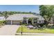Well-manicured lawn and mature landscaping accent this lovely home with a neutral color scheme and paver driveway at 1307 Forestedge Blvd, Oldsmar, FL 34677