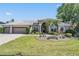 Charming home featuring lush landscaping, an attached garage, and a well-maintained lawn at 1307 Forestedge Blvd, Oldsmar, FL 34677