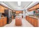 Well-lit kitchen features stainless steel appliances, granite countertops, and a center island at 1307 Forestedge Blvd, Oldsmar, FL 34677