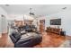 Spacious living room with hardwood floors, leather seating, and open floor plan at 1307 Forestedge Blvd, Oldsmar, FL 34677